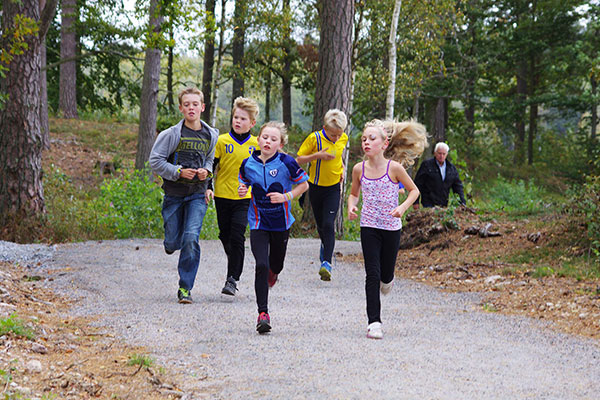 Barn joggar i skogen